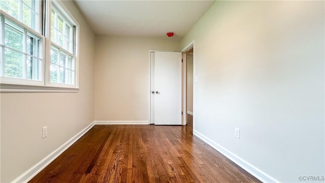 unfurnished bedroom with dark wood-type flooring