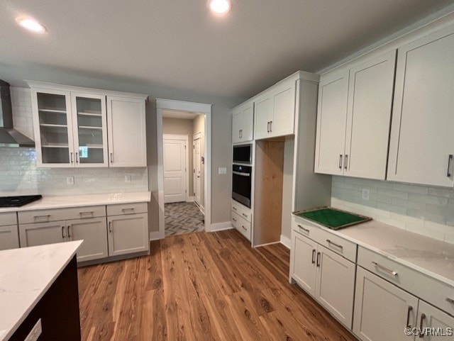 TBD1 Park St, Ashland, VA 23005 - kitchen with appliances with stainless steel finishes, wall chimney exhaust hood, glass insert cabinets, wood finished floors, and tasteful backsplash