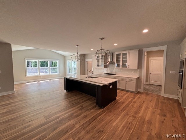 TBD1 Park St, Ashland, VA 23005 - kitchen featuring wall chimney range hood, light countertops, wood finished floors, a center island with sink, and vaulted ceiling