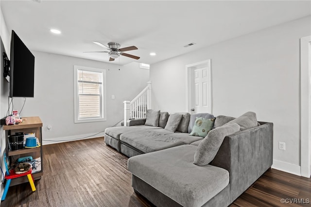 living room featuring ceiling fan and dark hardwood / wood-style flooring