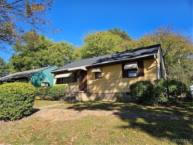 bungalow-style home with a front lawn