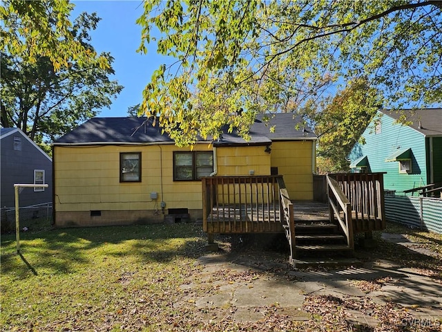 rear view of property featuring a yard and a deck