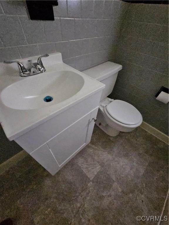 bathroom with vanity, backsplash, and toilet