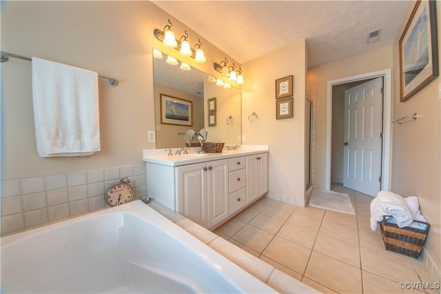 bathroom featuring tile patterned flooring, vanity, a textured ceiling, and plus walk in shower