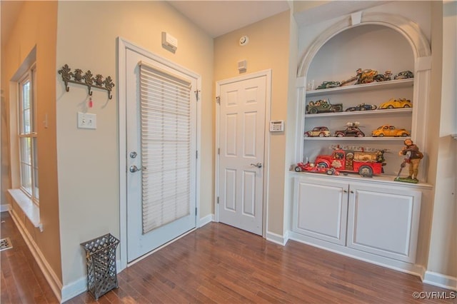 doorway featuring built in shelves and dark hardwood / wood-style flooring