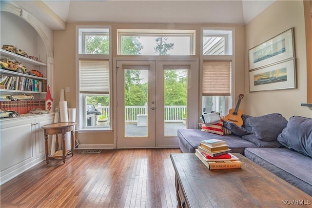 doorway featuring hardwood / wood-style floors, vaulted ceiling, french doors, and a healthy amount of sunlight