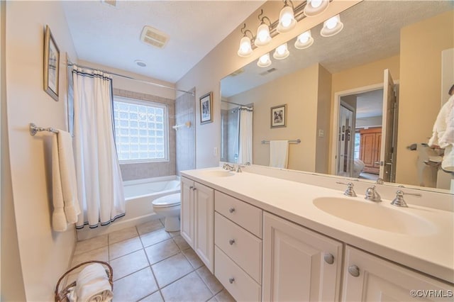 full bathroom featuring toilet, tile patterned floors, vanity, and shower / tub combo with curtain