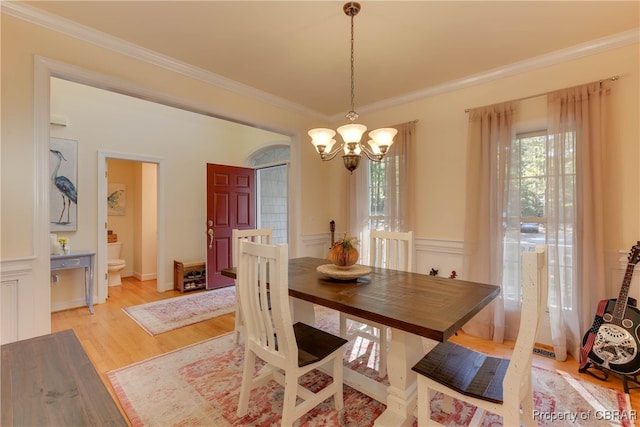 dining room featuring a chandelier, light hardwood / wood-style floors, and ornamental molding