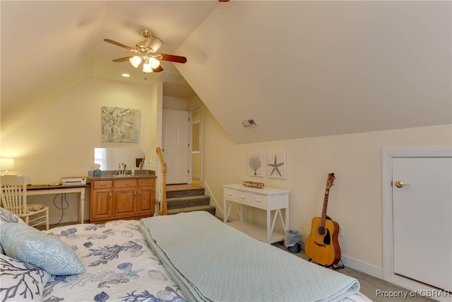 carpeted bedroom with ceiling fan, sink, and vaulted ceiling