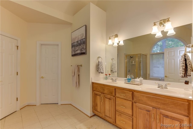 bathroom with tile patterned floors, vanity, a shower with shower door, and a notable chandelier