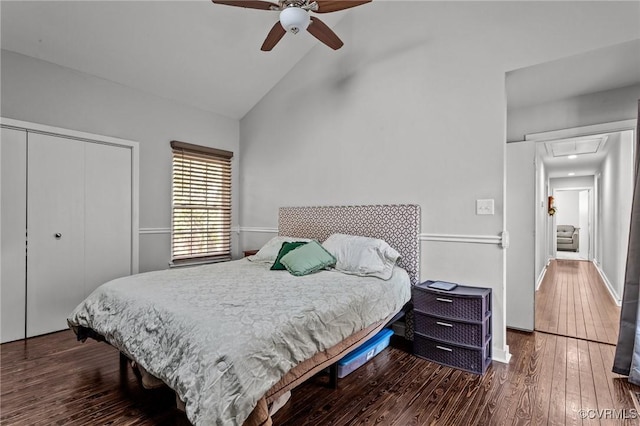 bedroom featuring ceiling fan, dark wood-type flooring, high vaulted ceiling, and a closet