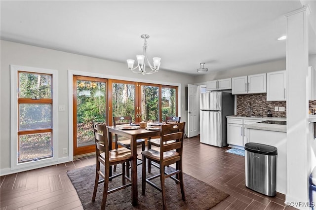 dining area featuring sink and an inviting chandelier