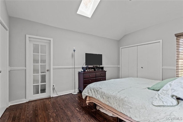 bedroom with dark hardwood / wood-style flooring, lofted ceiling with skylight, and a closet