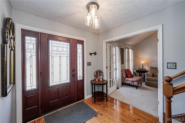 foyer entrance with a healthy amount of sunlight, light hardwood / wood-style flooring, and a textured ceiling