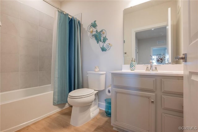 full bathroom with hardwood / wood-style floors, vanity, toilet, and shower / bath combo with shower curtain