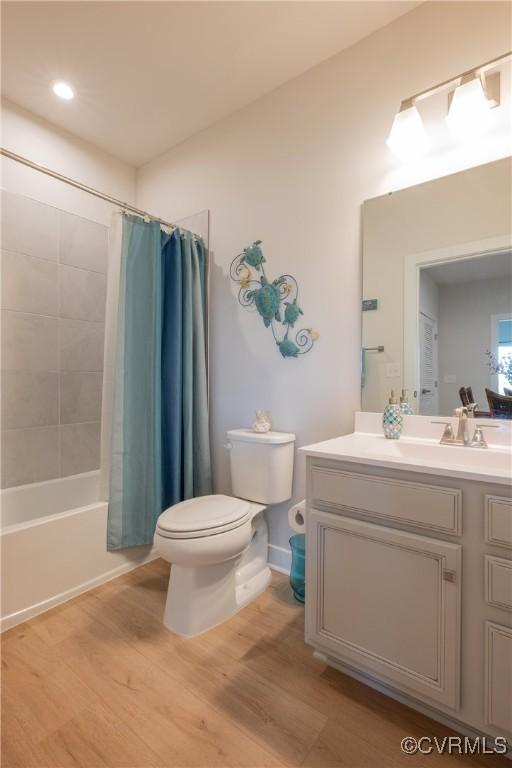 full bathroom with toilet, vanity, shower / bath combination with curtain, and wood-type flooring