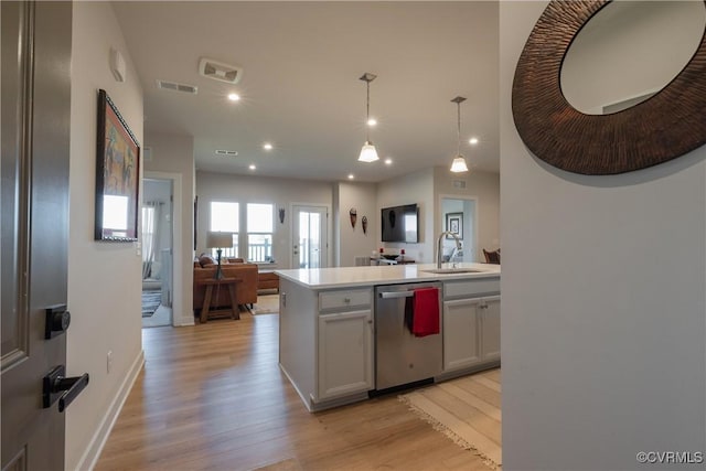 kitchen with dishwasher, light wood-type flooring, decorative light fixtures, and sink