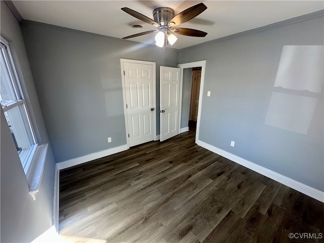 unfurnished bedroom featuring ceiling fan, ornamental molding, and dark hardwood / wood-style floors