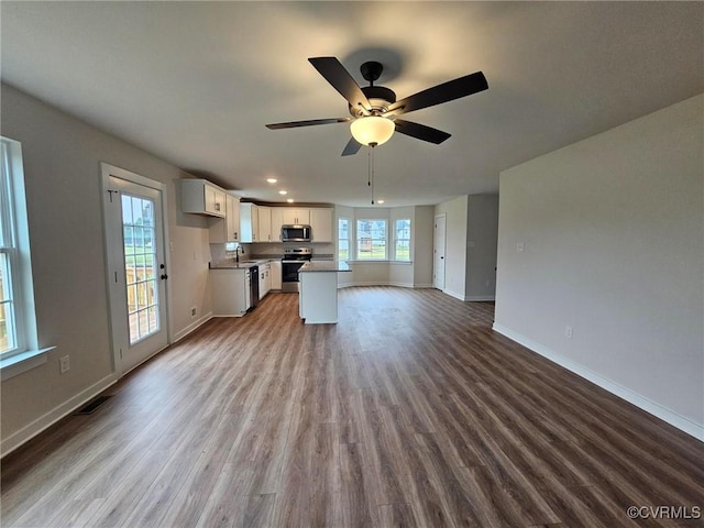 unfurnished living room with ceiling fan, sink, and light hardwood / wood-style flooring