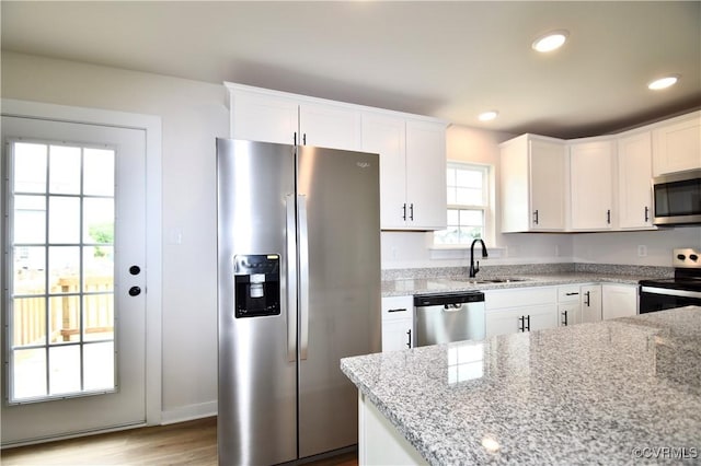 2625 Butterbean Ct, Henrico, VA 23231 - kitchen featuring appliances with stainless steel finishes, a sink, white cabinetry, light stone countertops, and light wood-type flooring