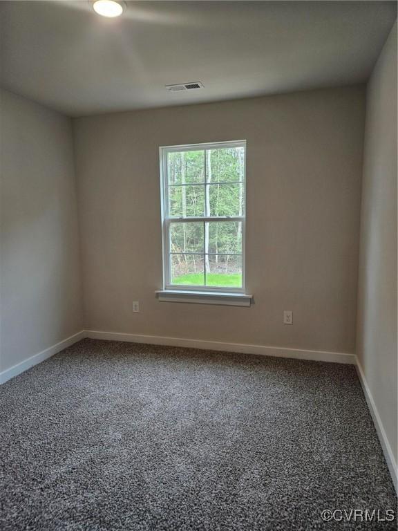 unfurnished room featuring visible vents, carpet, and baseboards