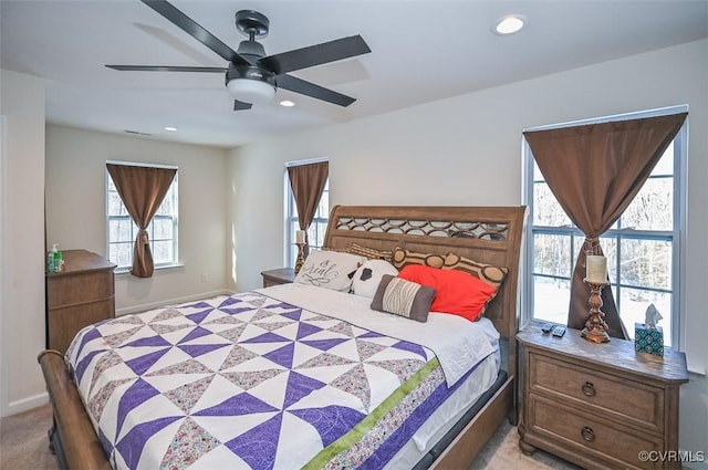 carpeted bedroom featuring multiple windows and ceiling fan