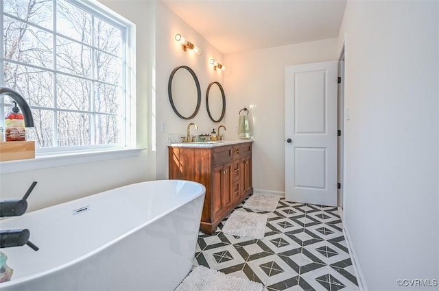 bathroom featuring a washtub, tile patterned floors, vanity, and plenty of natural light