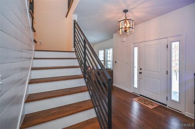 entrance foyer featuring an inviting chandelier, plenty of natural light, and dark wood-type flooring