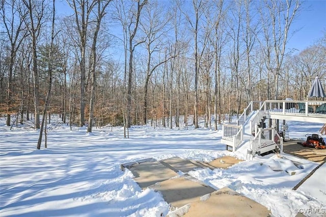 snowy yard featuring a deck