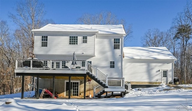 snow covered house featuring a wooden deck