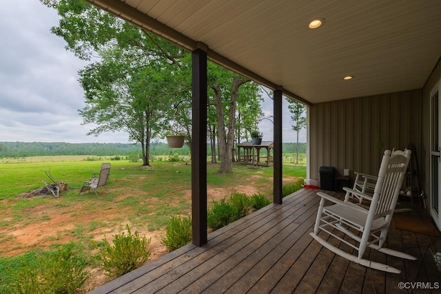 wooden deck featuring a lawn and a rural view