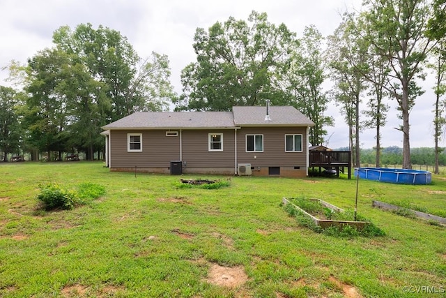 back of house featuring a lawn, a pool side deck, and cooling unit