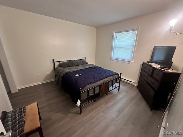 bedroom featuring dark wood-type flooring and a baseboard heating unit