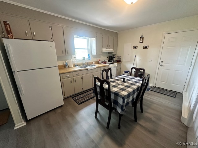 kitchen featuring wood-type flooring, white appliances, and sink