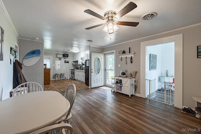 dining room with ceiling fan, crown molding, and dark wood-type flooring