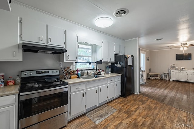 kitchen with dark hardwood / wood-style flooring, white cabinetry, black fridge, and electric stove