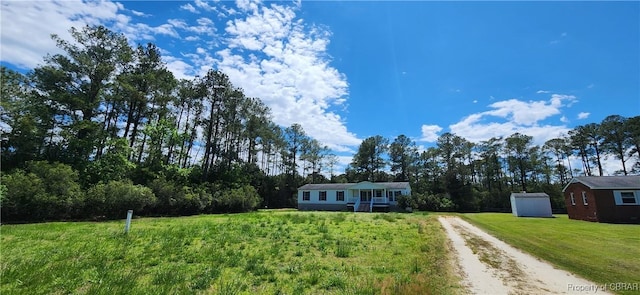 single story home with a storage shed and a front lawn