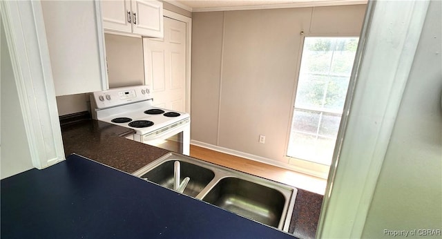 kitchen with white cabinetry, white range with electric cooktop, ornamental molding, and sink