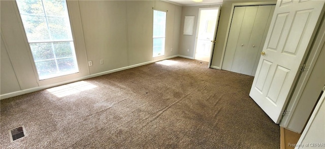 unfurnished bedroom with carpet flooring, multiple windows, a closet, and ornamental molding