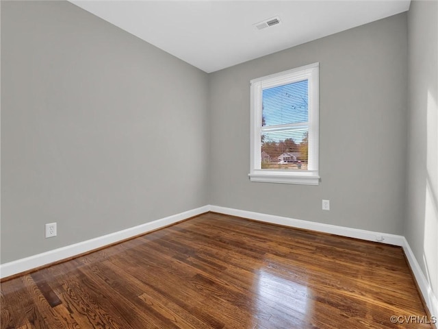 unfurnished room with dark wood-type flooring