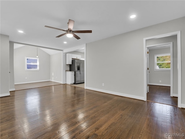 unfurnished living room with lofted ceiling, dark hardwood / wood-style flooring, and ceiling fan