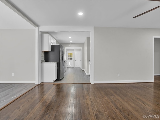 unfurnished living room with dark wood-type flooring and ceiling fan