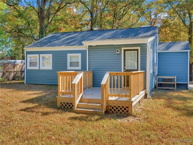 rear view of house with a lawn and a deck