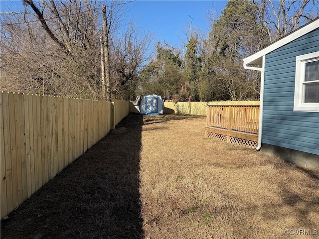 view of yard featuring a storage unit and a deck