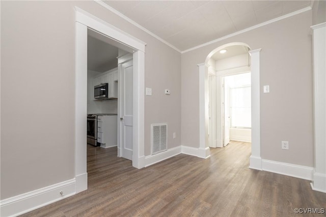 empty room featuring crown molding and hardwood / wood-style floors