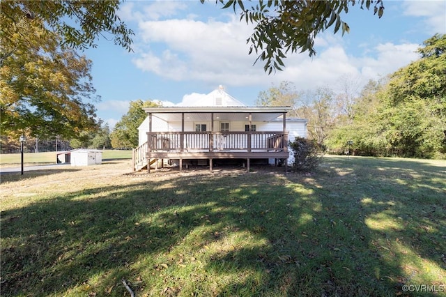 back of property featuring a shed, a deck, and a yard