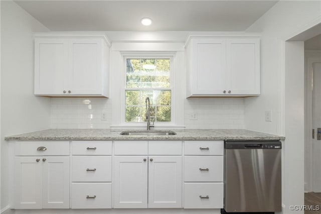 kitchen featuring sink, stainless steel dishwasher, decorative backsplash, light stone countertops, and white cabinetry