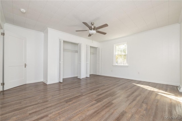 unfurnished bedroom featuring ceiling fan, crown molding, and dark wood-type flooring