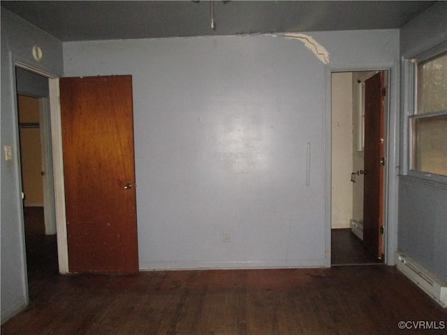 spare room with a baseboard radiator and dark hardwood / wood-style floors