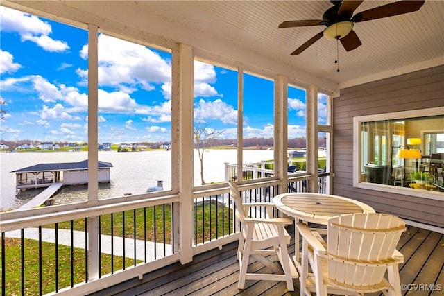 sunroom featuring a water view and ceiling fan